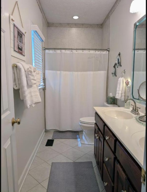 Bathroom with tiled shower and vanity
