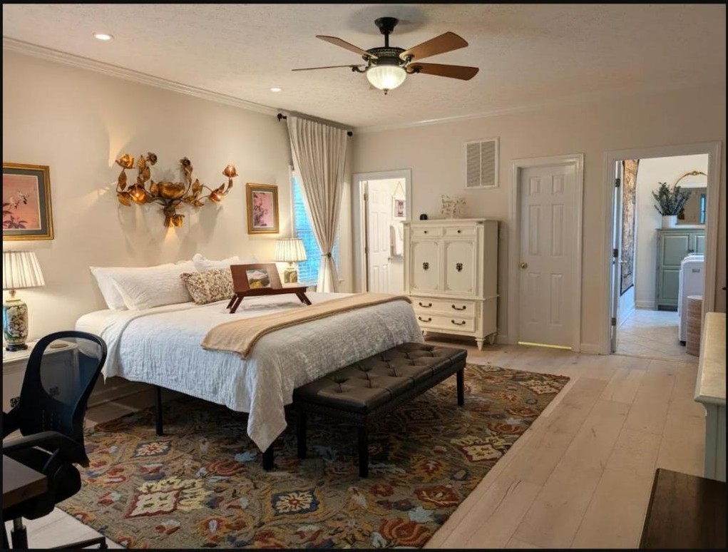 Full view of the king bedroom with ceiling fan, dresser, and vintage rug