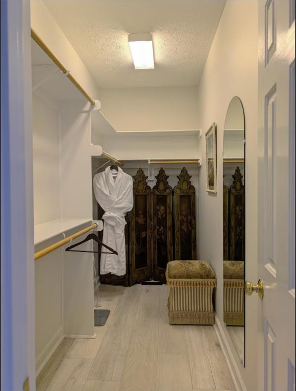Walk-in closet with a robe and folding screen