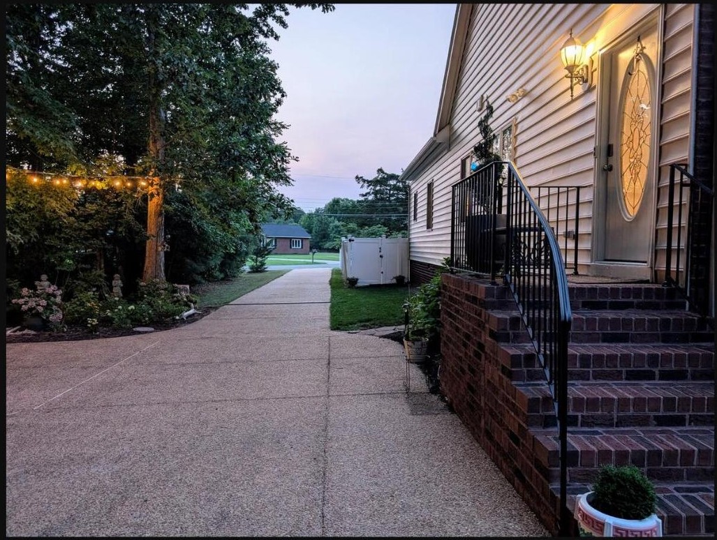Brick steps and glowing entry door of the Granny Chic Suite at dusk