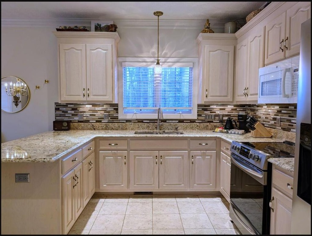 Full kitchen with granite counters, tile backsplash, and a sunny window over the sink