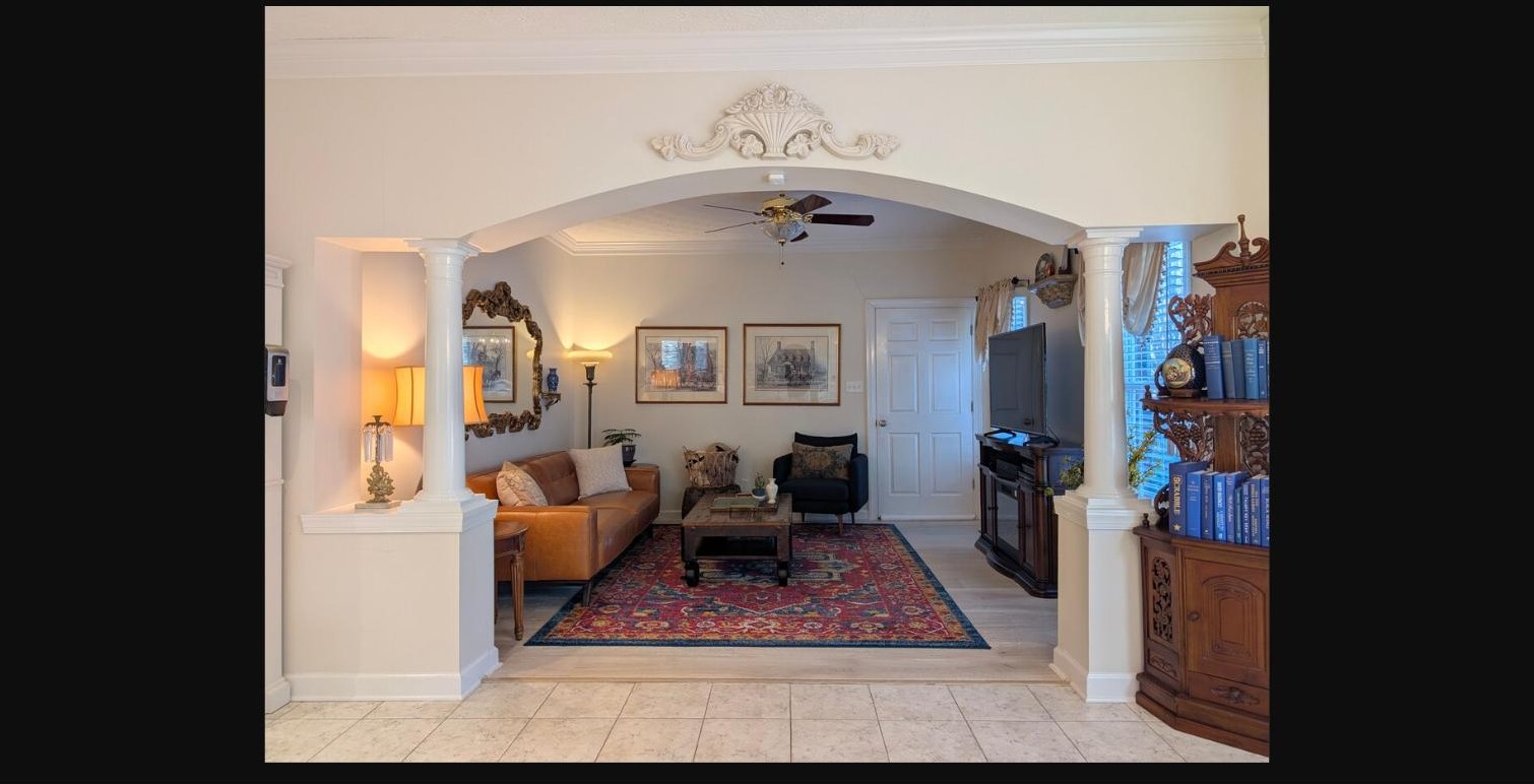 Living room viewed through an arched, column-framed doorway